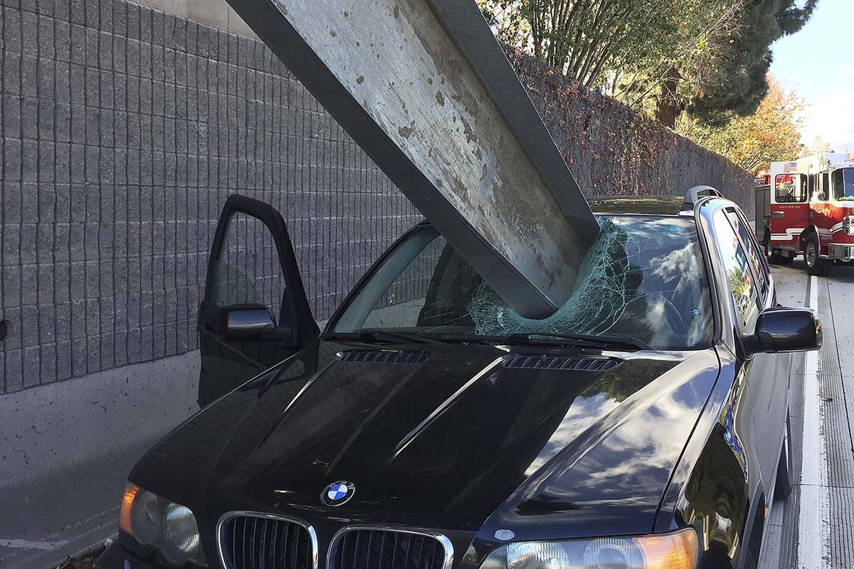 This photo provided by the San Jose Fire Department shows a beam that fell off of a flatbed truck that impaled the window of a BMW car on I-280 in San Jose, Calif. 