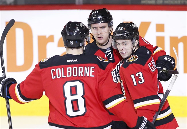 Calgary Flames' Johnny Gaudreau, right, celebrates a goal against the Edmonton Oilers' with Mikael Backlund, cente, from Sweden, and Joe Colborne during second period NHL action in Calgary, Alta., Sunday Dec. 27, 2015. THE CANADIAN PRESS/Larry MacDougal.