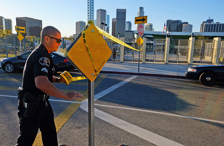 A police officer puts up yellow tape outside of Edward Roybal High School in Los Angeles, on Tuesday morning, Dec. 15, 2015. 