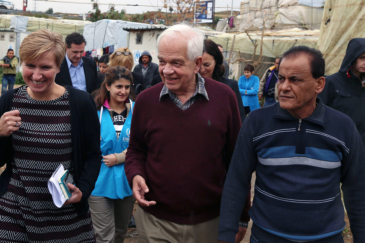 Canadian Minister of Immigration John McCallum, center, walks during his visit to a Syrian refugee camp in the southern town of Ghaziyeh, near the port city of Sidon, Lebanon, Friday, Dec. 18, 2015.