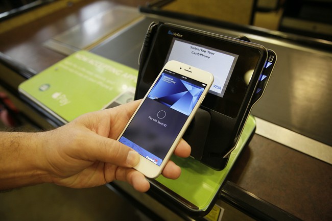Eddy Cue, Apple Senior Vice President of Internet Software and Services, demonstrates the new Apple Pay mobile payment system at a Whole Foods store in Cupertino, Calif. 
