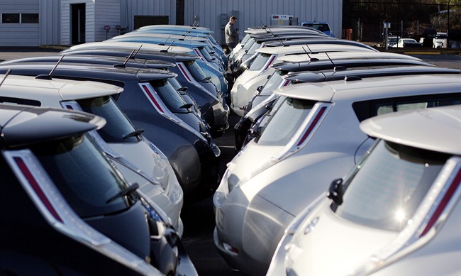FILE - In this file photo, electric vehicles sit on display at an auto dealership.