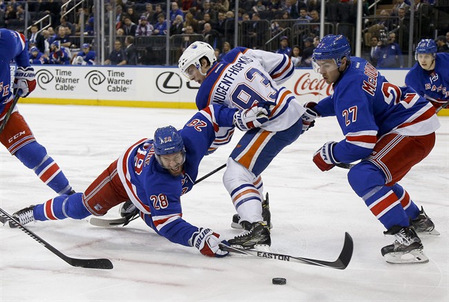 New York Rangers centre Dominic Moore (28) hits the ice as he reaches for the puck against Edmonton Oilers center Ryan Nugent-Hopkins (93) during a faceoff during the first period of an NHL hockey game, Tuesday, Dec. 15, 2015, in New York. (AP Photo/Julie Jacobson).