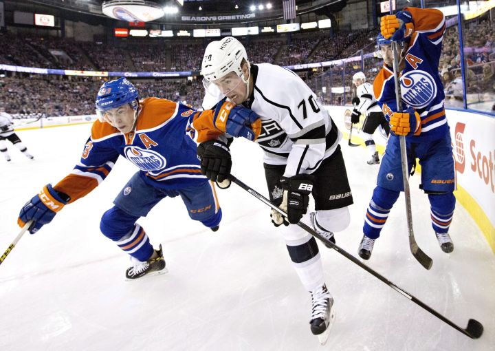 Los Angeles Kings' Tanner Pearson (70) battles for the puck with Edmonton Oilers' Ryan Nugent-Hopkins (93) and Jordan Eberle (14) during first period NHL action, in Edmonton, on Tuesday, December 29, 2015. 