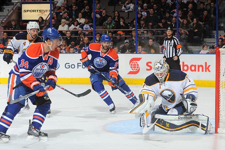 Benoit Pouliot #67 and Jordan Eberle #14 of the Edmonton Oilers take the puck hard to the net but are stopped by Jhonas Enroth #1 of the Buffalo Sabres on January 29, 2015 at Rexall Place in Edmonton, Alberta, Canada. 