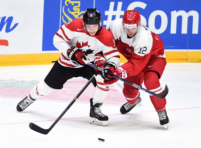 Canada's Rourke Chartier fights for the puck against Denmark's Christian Mieritz during first period preliminary hockey action at the IIHF World Junior Championship in Helsinki, Finland on Monday, December 28, 2015.