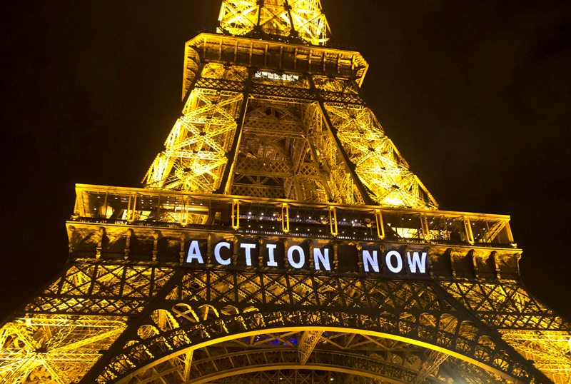 The Eiffel Tower lights up with the slogan"Action Now"referring to the COP21, United Nations Climate Change Conference in Paris, Sunday, Dec. 6, 2015. Negotiators adopted a draft climate agreement Saturday that was cluttered with brackets and competing options, leaving ministers with the job of untangling key sticking points in what is envisioned to become a lasting, universal pact to fight global warming. 