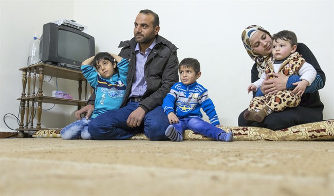 Mjdi Mnaahe, his wife Wessam and their sons Tamim, 6, Saif, 4 and Mohammad, 1, (left to right) sit in their apartment Monday, November 30, 2015 in Irbid, Jordan. 