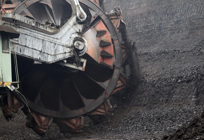 A huge excavator digs inside a giant open pit lignite mine.