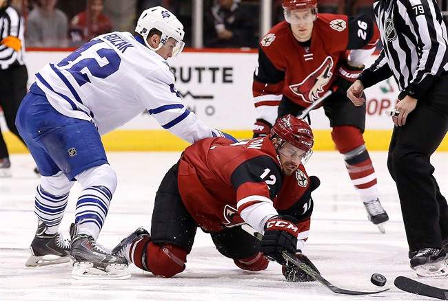 Arizona Coyotes' Brad Richardson (12) tries get the puck away from Toronto Maple Leafs' Tyler Bozak, left, during the first period of an NHL hockey game Tuesday, Dec. 22, 2015, in Glendale, Ariz. (AP Photo/Ross D. Franklin).
