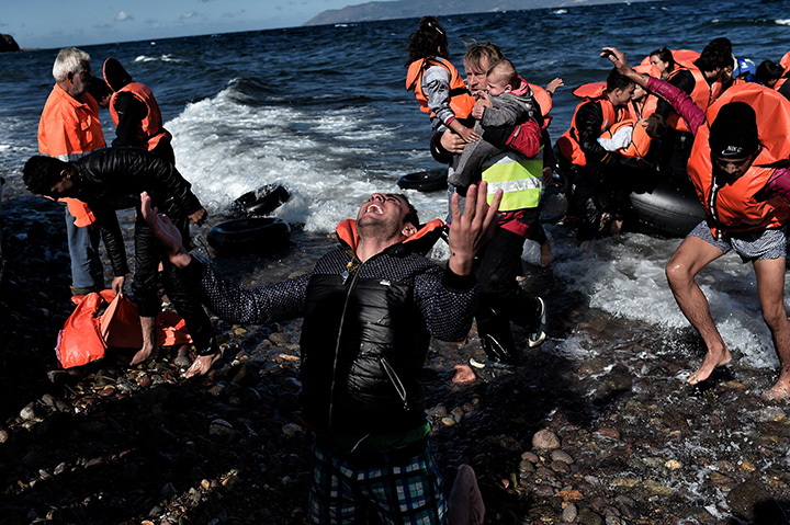 A man reacts as he arrives, with other refugees and migrants, on the Greek island of Lesbos, on October 28, 2015, after crossing the Aegean Sea from Turkey. 