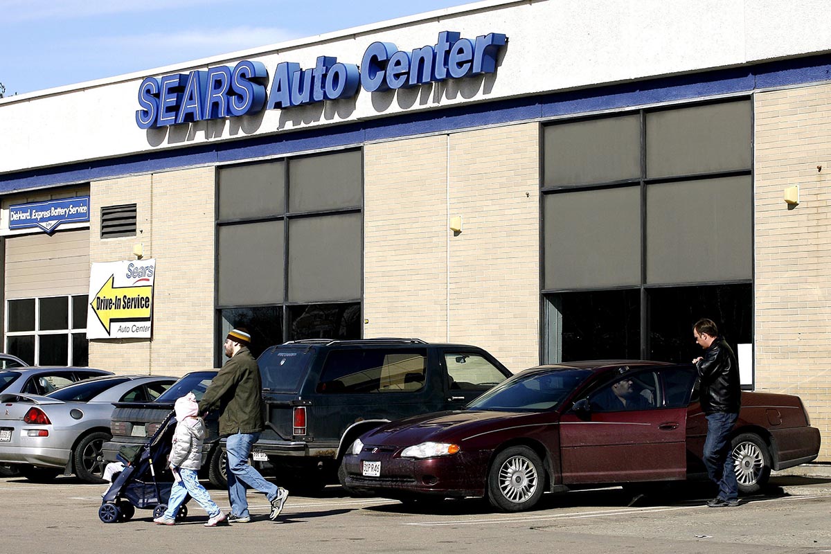 A customer walks with his daughter as a mechanic talks with another customer from his car outside a Sears Auto Center in Burlington, Mass. Thursday, March 1, 2007. 