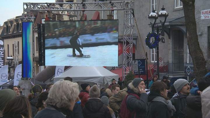 Spectators take in the action on the giant screen at urban snowboard competition on Saint-Denis Street. Saturday, Dec. 5, 2015.