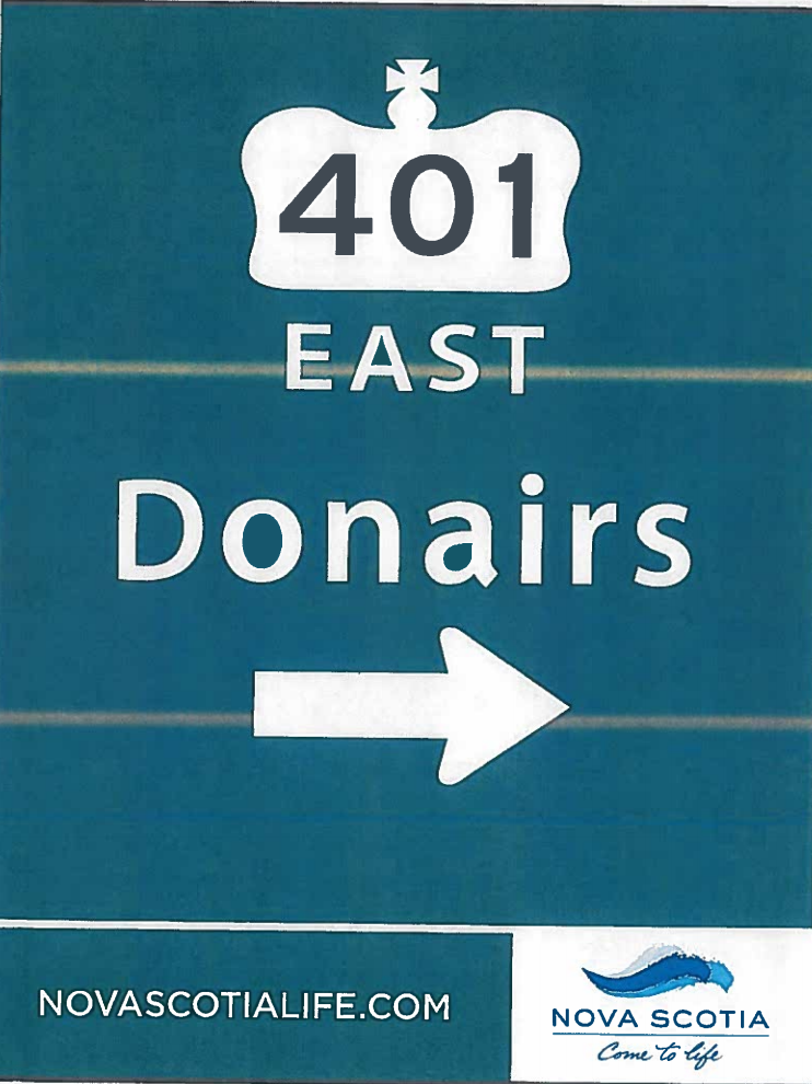 An ad for Nova Scotia features “Donairs” advertised on a highway sign within the province.
