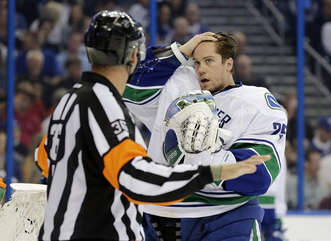 Vancouver Canucks goalie Jacob Markstrom (25), of Sweden, complains to referee Dean Morton (36) that he was hit after the whistle during the second period of an NHL hockey game against the Tampa Bay Lightning, Tuesday, Dec. 22, 2015, in Tampa, Fla. (AP Photo/Chris O'Meara).