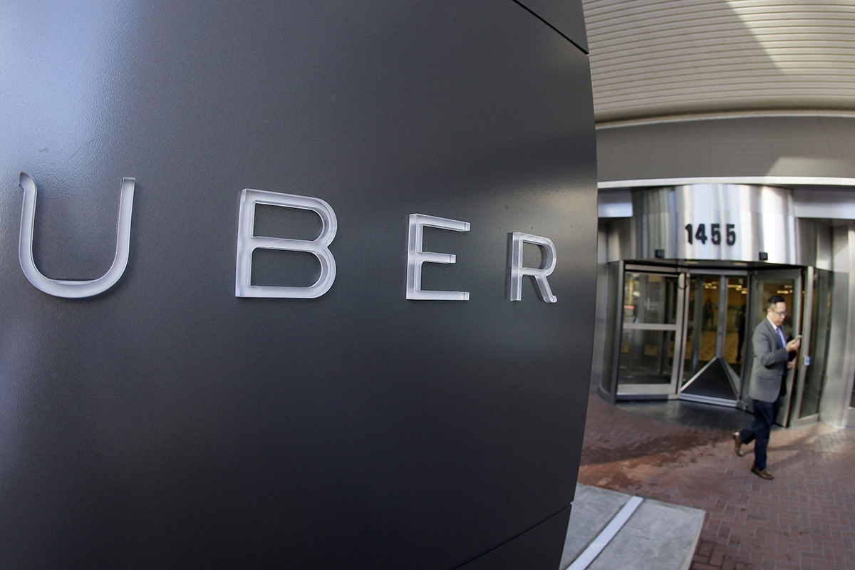In this Dec. 16, 2014, file photo a man leaves the headquarters of Uber in San Francisco. 