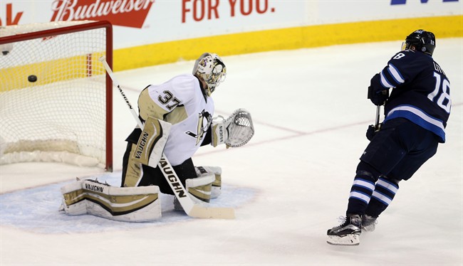 Winnipeg Jets' Bryan Little (18) scores on a penalty shot on Pittsburgh Penguins' goaltender Jeff Zatkoff (37) during first period NHL hockey action in Winnipeg, Sunday, December 27, 2015.