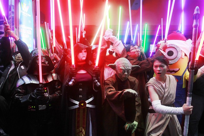 Fans dressed as Star Wars characters parade outside a movie theater showing "Star Wars: The Force Awakens".