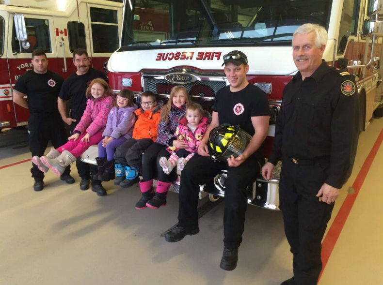 Hannah, Taylor, Nicholas, Hailey and Brianna join local firefighters after dropping off treats they bought after selling their doll house.