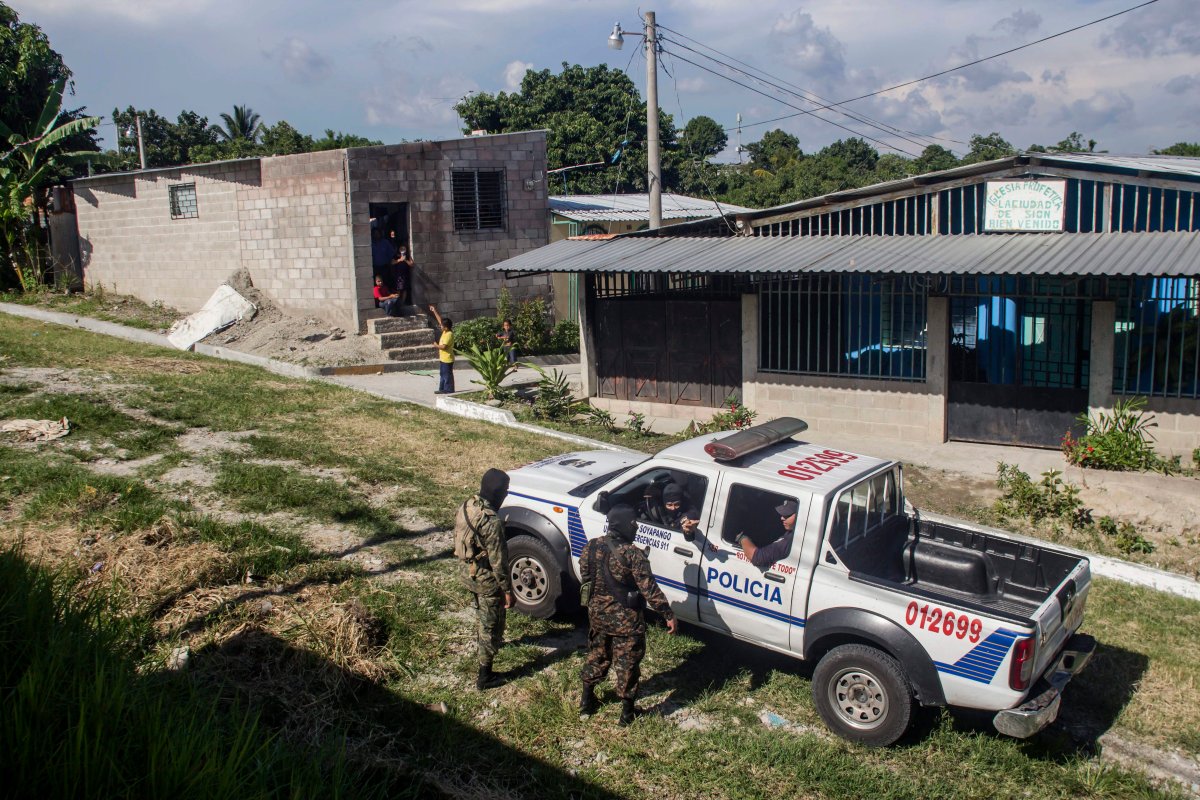 Soldiers on foot patrol talk with policemen in a gang controlled neighborhood in El Salvador. 