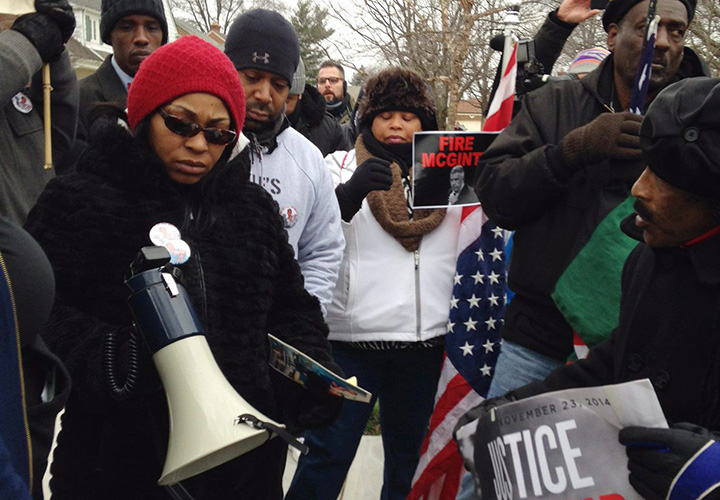 A march leader with a megaphone talks to protesters near the home of Cuyahoga County Prosecutor Tim McGinty in Cleveland on Friday, Jan. 1, 2016.