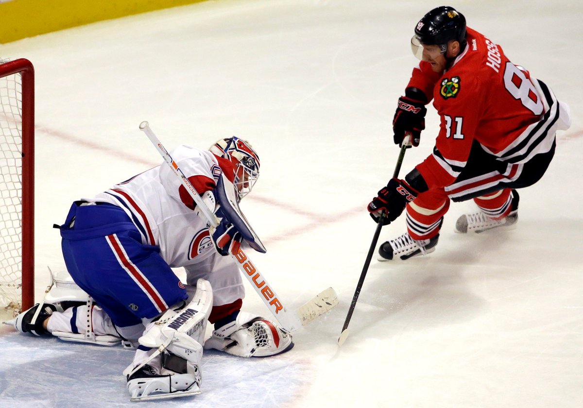 Montreal Canadiens goalie Ben Scrivens saves a shot by Chicago Blackhawks right wing Marian Hossa during the first period of an NHL hockey game Sunday, Jan. 17, 2016, in Chicago. 