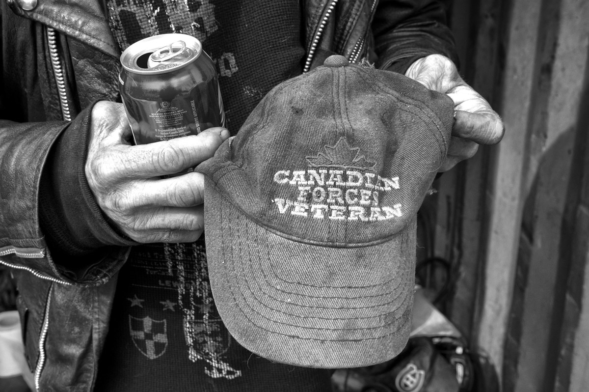 Claude Lord, a homeless veteran living in a shipping container in Montreal, shows a cap to a photographer. 