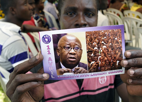 A supporter of Ivory Coast's former president Laurent Gbagbo holds a flyer picturing Gbagbo and reading in French "April 11 Solidarity with Laurent Gbagbo" during a demonstration on April 11, 2015 in Abidjan on the anniversary of Gbagbo's arrest by the International Criminal Court of The Hague, on charges of crimes against humanity after post-election violence in  2011. 