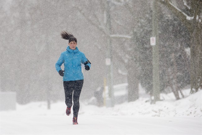A woman runs on a snow-covered street.