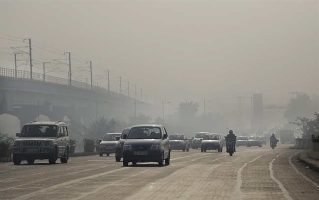 Vehicles move through morning smog on the first day of a two-week experiment to reduce the number of cars to fight pollution in New Delhi, India, Friday, Jan. 1, 2016. 