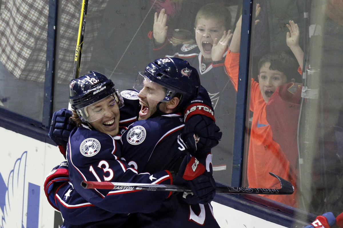 Columbus Blue Jackets' Cam Atkinson, left, celebrates with teammate Boone Jenner after Atkinson scored his third goal of the game.