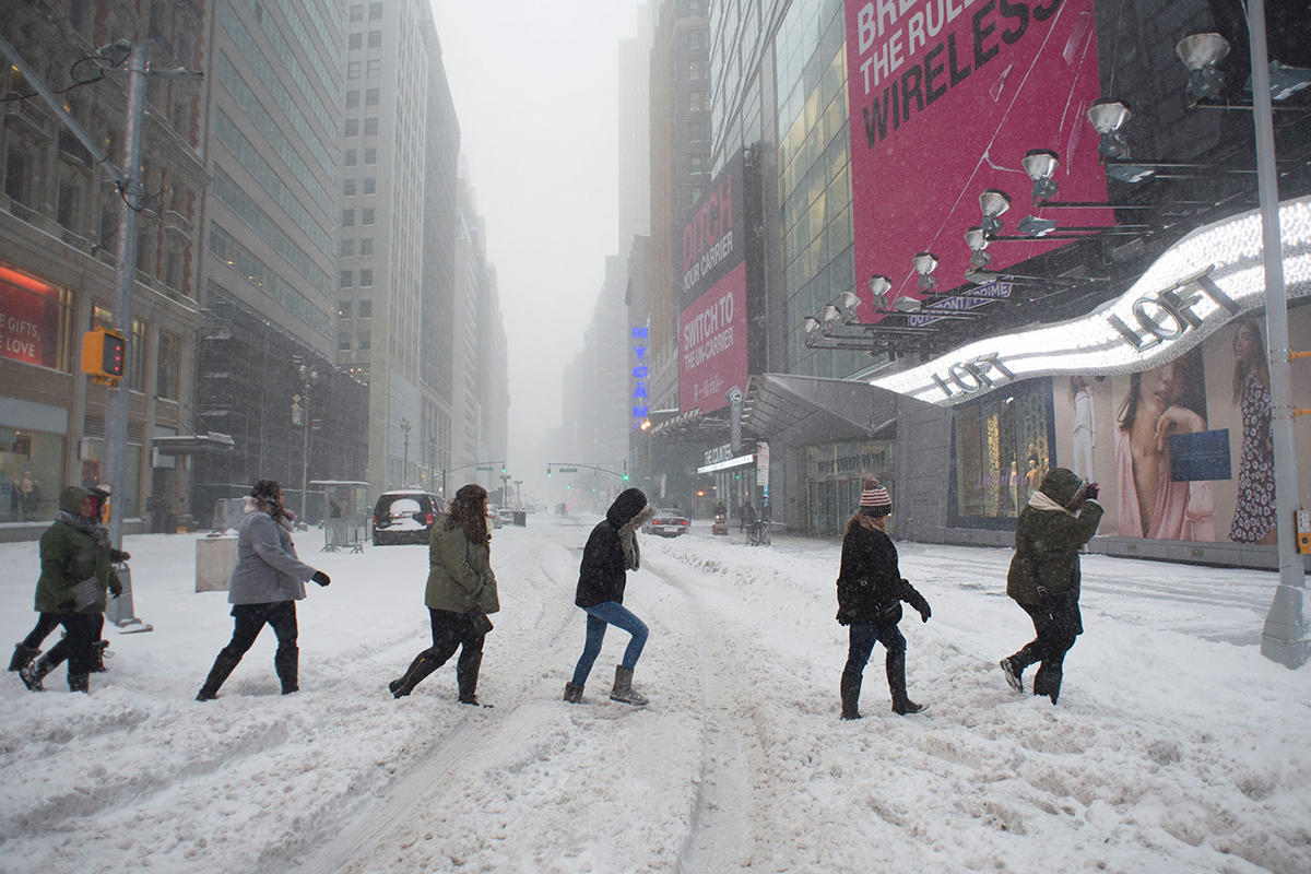 Pedestrians make their way across snow covered Broadway January 23, 2016 in New York.