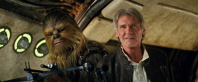 This photo provided by Lucasfilm shows Peter Mayhew as Chewbacca and Harrison Ford as Han Solo in "Star Wars: The Force Awakens.".