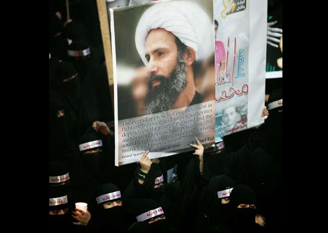 In this Sunday, Sept. 30, 2012 file photo, a Saudi anti-government protester carries a poster with the image of jailed Shiite cleric Sheik Nimr al-Nimr during the funeral of three Shiite Muslims allegedly killed by Saudi security forces in the eastern town of al-Awamiya, Saudi Arabia.