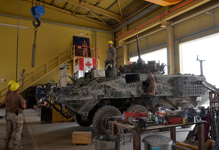 Civilian and military vehicle technicians strip down and clean a Canadian light armoured vehicle (LAVIII) in this Friday July 15, 2011 file photo. 