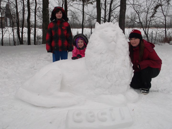 Libby Clinch and her children, Jack (10) and Audrey (6), take a photo with her ice sculpture tribute to Cecil the lion, Sunday, January 3, 2016.
