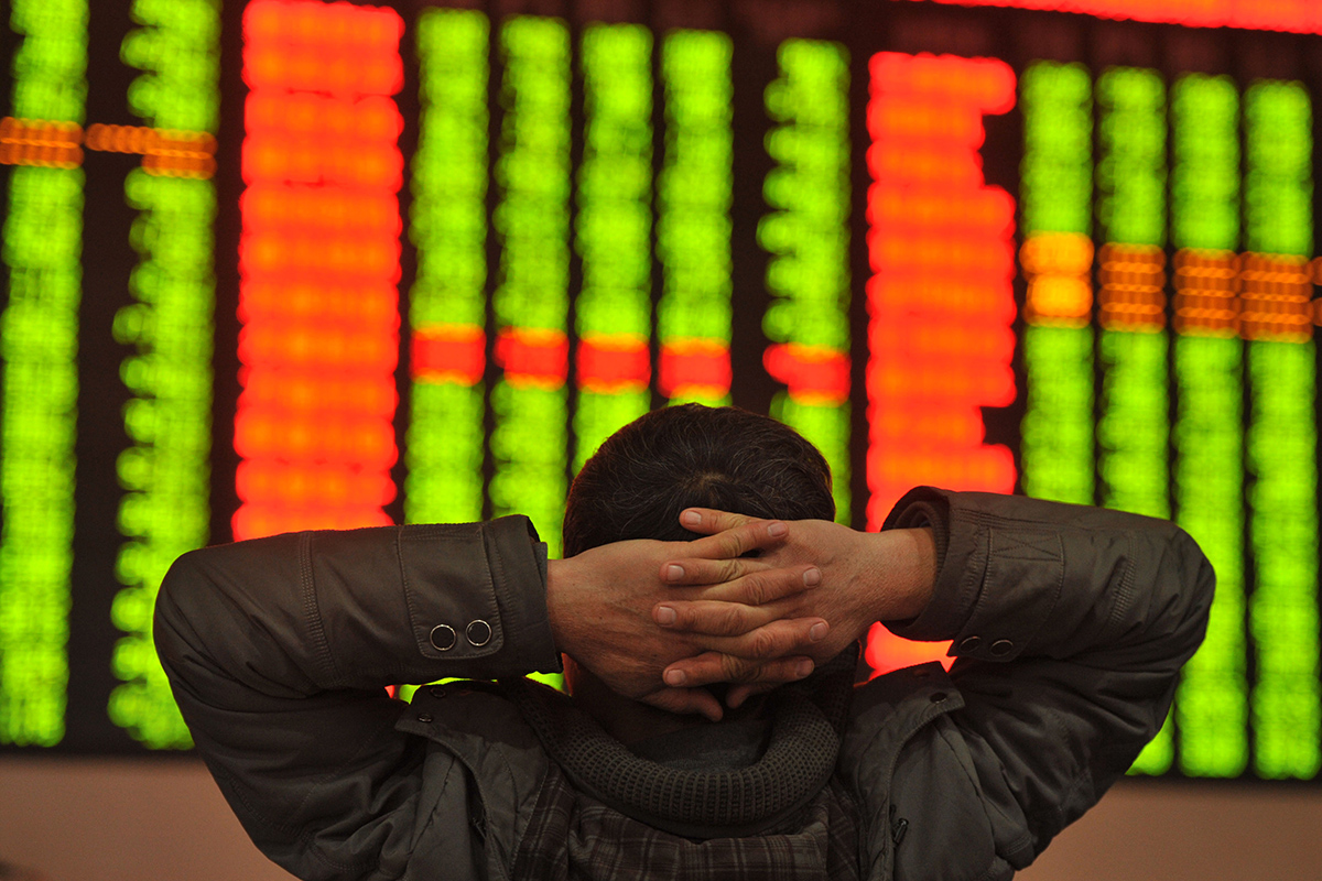 An investor sits in front of a screen showing stock market movements in a stock firm in Fuyang, east China's Anhui province on January 4, 2016. 