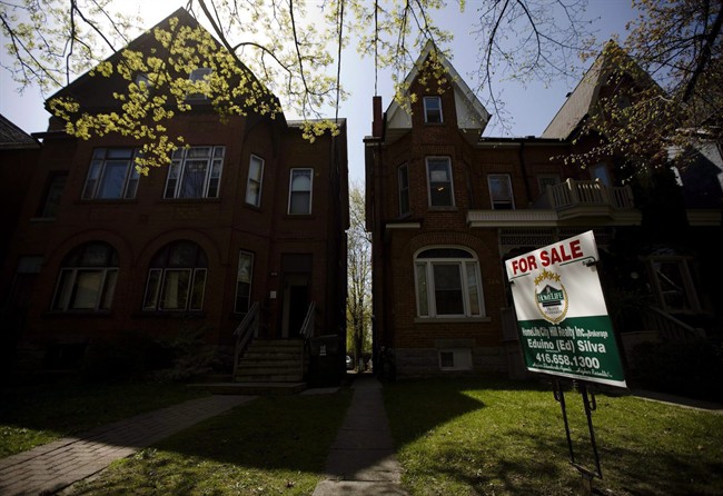 A "For Sale" sign sits in front of a house, in Toronto, on April 20, 2010.