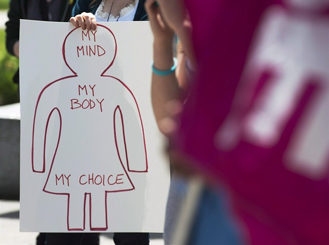 File - A protester holds a pro-choice sign at Victoria Park, in Halifax, during a demonstration for access to abortion services on the one-year anniversary of the death of Dr. Henry Morgentaler, May 29, 2014.