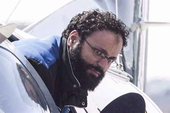 Chiheb Esseghaier is led off a plane by an RCMP officer at Buttonville Airport just north of Toronto on April 23, 2013. 