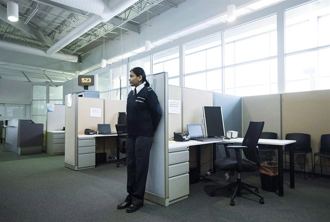 A security guard stands watch at the Canadian Border Services Agency's integrated processing area at Pearson International Airport in Toronto, Ont. on Tuesday, December 8, 2015. Canada's new security system for scrutinizing people who arrive by airplane singled out more than 2,300 passengers for closer examination during a recent three-month period, the federal border agency says. THE CANADIAN PRESS/Darren Calabrese.