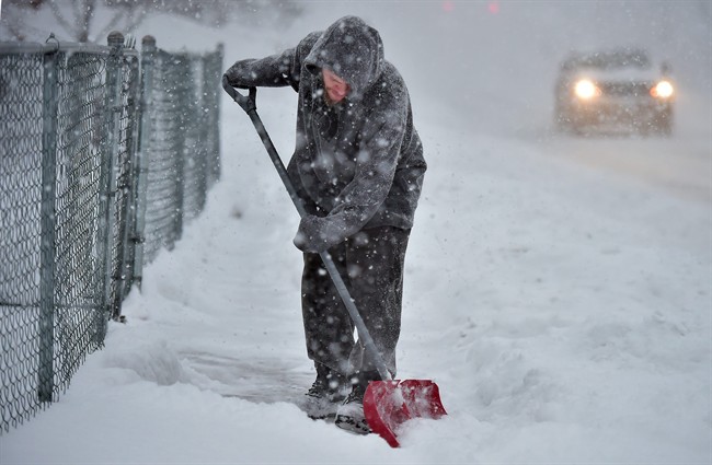 Julio Pagan shovels the sidewalk in front of his home on Middletown Avenue in New Haven, Conn., Saturday, Jan. 23, 2016.