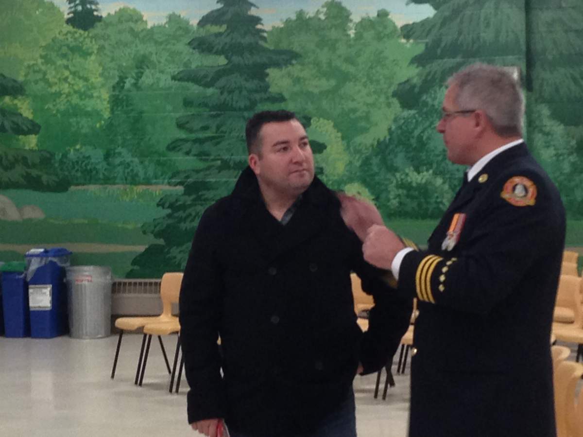 Halifax Regional Fire and Emergency Executive Fire Officer Phil McNulty (right) speaks to a member of the public at a firefighter recruitment information session in Dartmouth on Jan. 16, 2016.