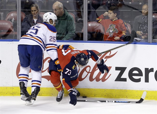 Florida Panthers center Brandon Pirri (73) is checked by Edmonton Oilers defenseman Darnell Nurse (25) during the first period of an NHL hockey game, Monday, Jan. 18, 2016, in Sunrise, Fla. 