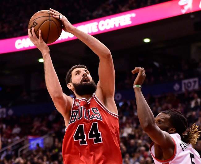 Chicago Bulls' Nikola Mirotic (left) grabs a rebound over Toronto Raptor's DeMarre Carroll during first half NBA basketball action in Toronto on Sunday, Jan.3, 2016.