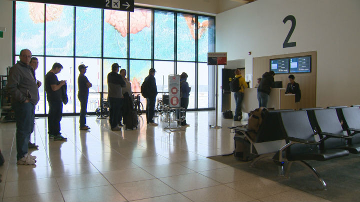 Passengers line up for a flight to Toronto at the airport in Fort McMurray, Alberta.