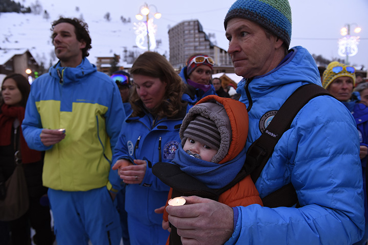 People holding candles observe a minute of silence in memory of the victims of the avalanche, on January 14, 2016 at Les Deux Alpes resort in the French Alps, a day after an avalanche swept away skiers, including a group on a school outing. 