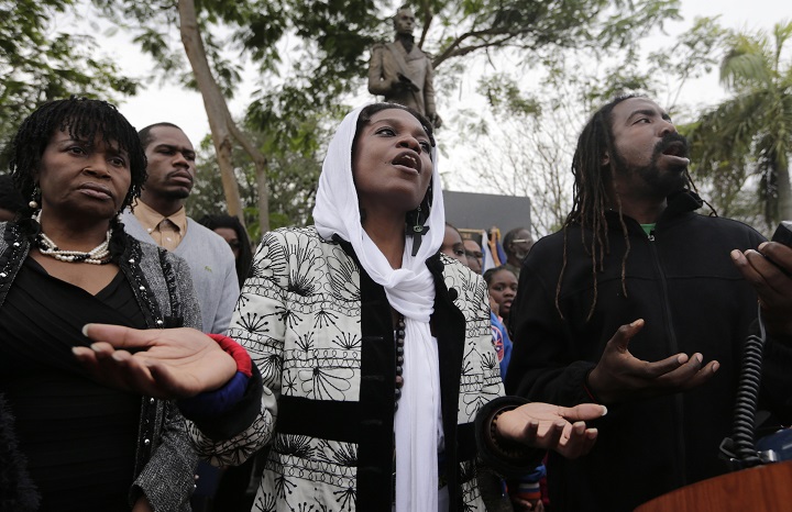 Diana Severin, center, and Jeffrey Pluviose, right, sing the national anthem of Haiti during a ceremony commemorating the sixth anniversary of the earthquake in Haiti, Tuesday, Jan. 12, 2016, in the Little Haiti neighborhood of Miami. 