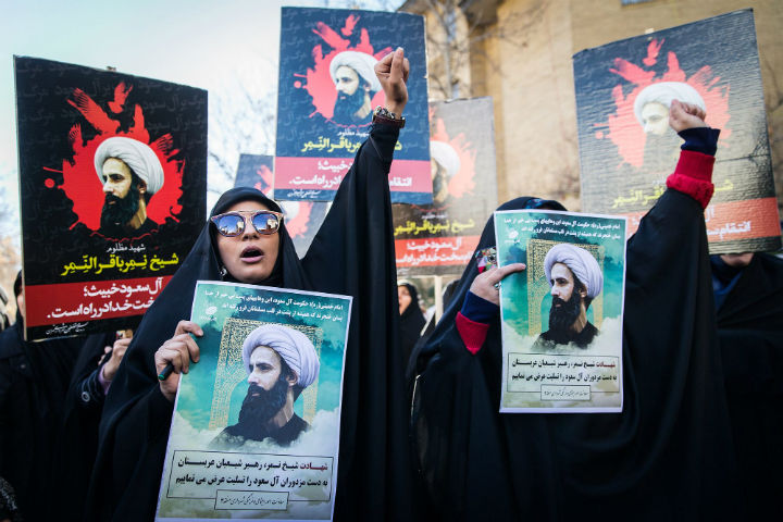 Iranian protesters hold portraits of prominent Shiite Muslim cleric Nimr al-Nimr as they confront riot police during a demonstration against his execution by Saudi authorities, on January 3, 2016, outside the Saudi embassy in Tehran, Iran. 