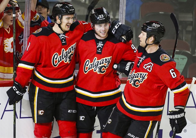 Calgary Flames' Sam Bennett, centre, celebrates his fourth goal with teamates Mikael Backlund, left, from Sweden, and Dennis Wideman during third period NHL hockey action against the Florida Panthers in Calgary, Wednesday, Jan. 13, 2016. 